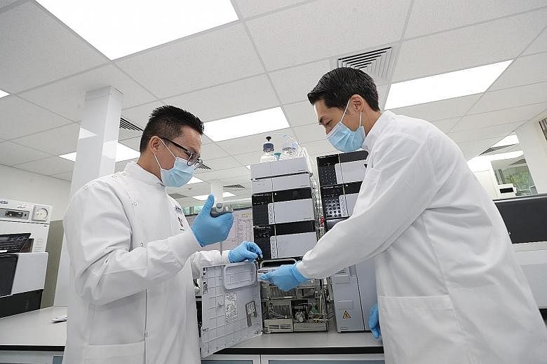 Dr Daryl Hee (left), a CGH senior manager in charge of the Shimadzu-CGH Clinomics Centre, and clinical assistant professor Troy Puar operating a liquid chromatography tandem mass spectrometer at the new facility.