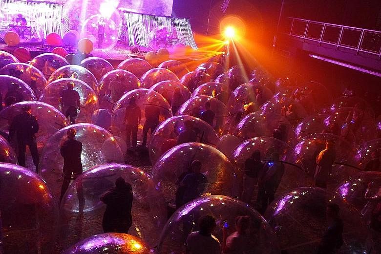 Concertgoers (above) at The Flaming Lips' concerts in Oklahoma (top) danced along in plastic bubbles.