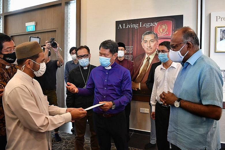Reverend Keith Lai, president of the National Council of Churches of Singapore (NCCS), handing an NCCS statement to Mufti Nazirudin Mohd Nasir at a meeting between Christian and Muslim leaders at Yusof Ishak Mosque in Woodlands yesterday morning. Als