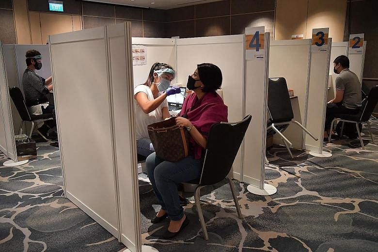 Hotel staff getting their Covid-19 vaccine shots at a vaccination centre in Raffles City Convention Centre yesterday. The hospitality industry was picked as an early recipient of the vaccine as its workers have been on the front lines since March las