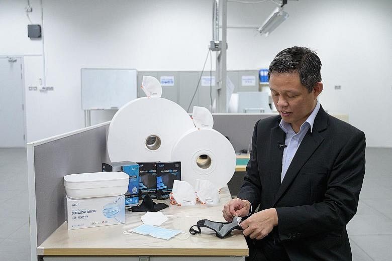 Trade and Industry Minister Chan Chun Sing inserting the filter produced by ST Engineering into a reusable mask yesterday, during a visit to the local firm. Singapore will build up its stockpile of these filters for future needs.