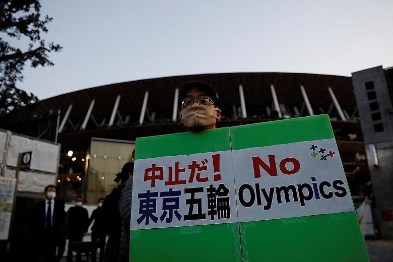A local makes his feelings known during IOC chief Thomas Bach's visit last year. Up to 80 per cent of Japanese are against holding the Games.