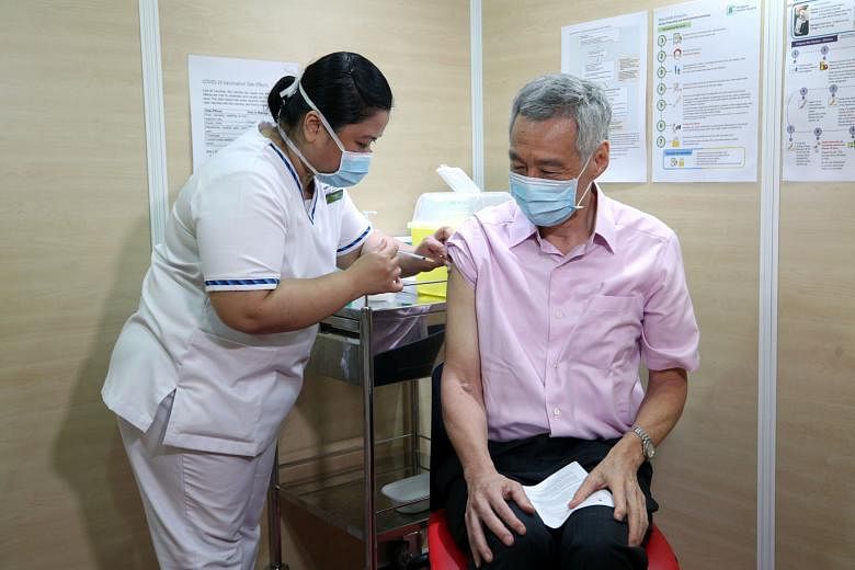Prime Minister Lee Hsien Loong receiving his second dose of the Covid-19 vaccine at the Singapore General Hospital yesterday. It was administered by senior staff nurse Fatimah Mohd Shah, who had given him the first dose.