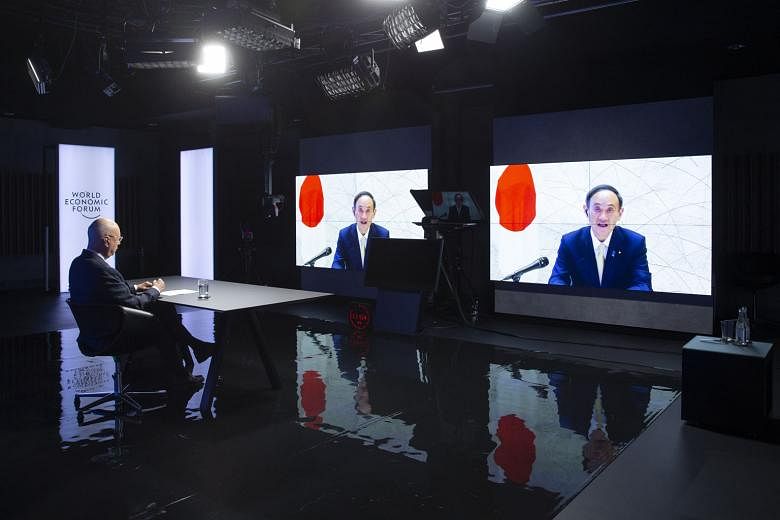 World Economic Forum founder and chairman Klaus Schwab watching Japanese Prime Minister Yoshihide Suga speak during a videoconference yesterday at the Davos Agenda in Cologny, near Geneva, Switzerland.