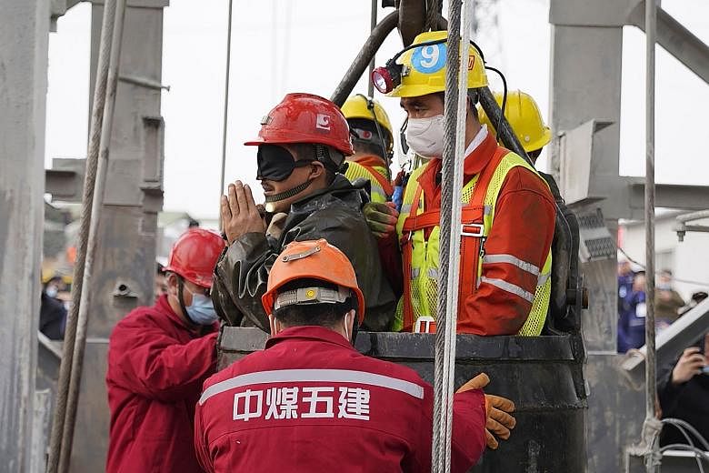 A miner wearing an eye mask being taken to safety by rescuers in Qixia last week. The miner's eyes were covered for protection since he had spent a prolonged period in darkness.
