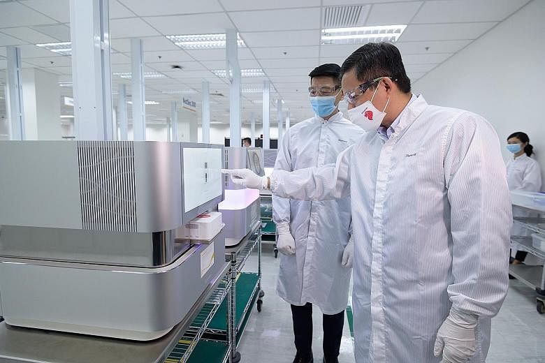 Trade and Industry Minister Chan Chun Sing (at right) and Illumina Singapore vice-president and general manager Derric Lee on a tour of the biotech firm's facilities yesterday. Mr Chan said that with leading companies in the manufacturing sector sett