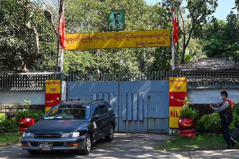 Left: A car leaving the Yangon residence of State Counsellor Aung San Suu Kyi (right) yesterday. Ms Suu Kyi was detained, and replaced as Foreign Minister, after a military coup on Monday. The Myanmar government, under commander-in-chief Min Aung Hla