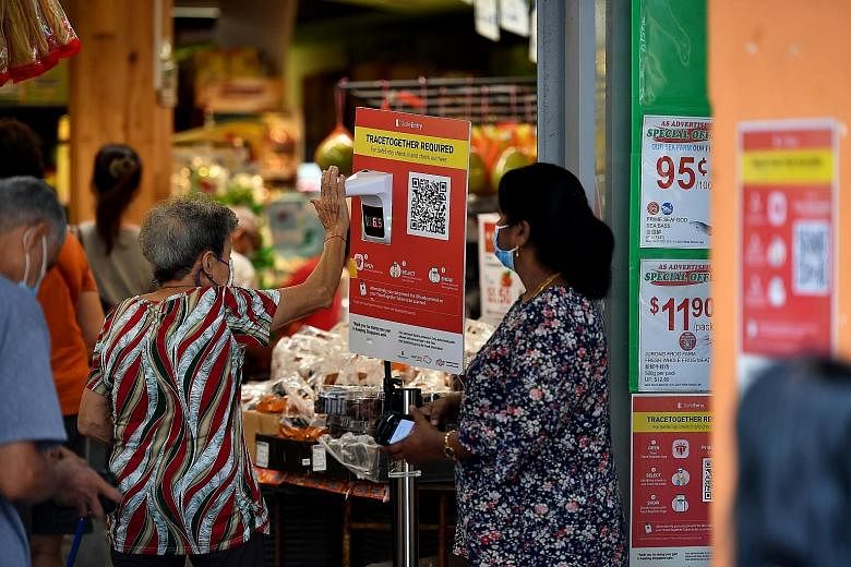 A temperature scanner and poster on TraceTogether at the entrance of Prime Supermarket in Tampines Street 81. Under changes to the law passed yesterday, contact tracing data from TraceTogether can be used for police investigations only for seven cate