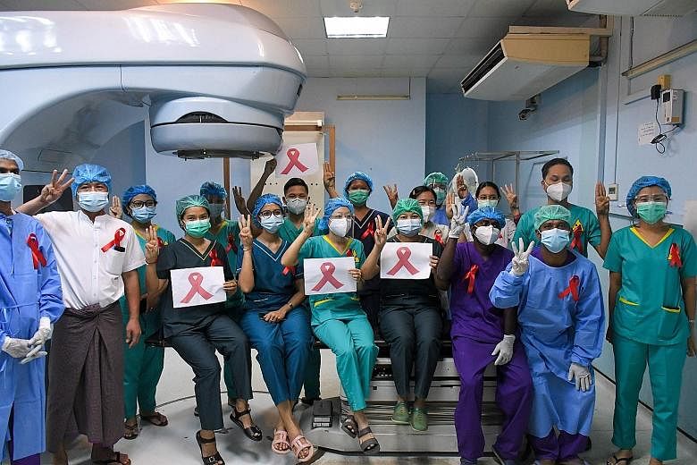 Above: In peaceful acts of civil disobedience yesterday, doctors and other medical workers in Yangon (above) wore red ribbons to work and did the three-finger salute, which is widely used by pro-democracy supporters in neighbouring Thailand as a symb