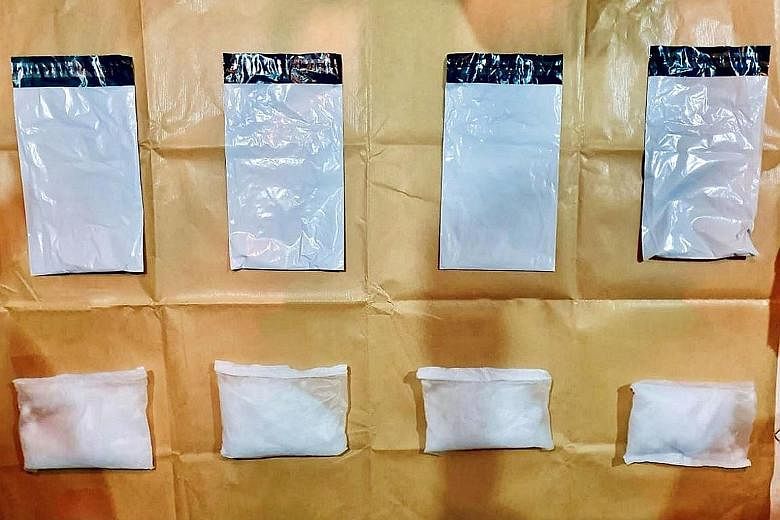 Controlled drugs (left) and packets of Ice (far left) seized by the Central Narcotics Bureau from a home near Bukit Batok West Avenue 6 on Tuesday. Officers searched the home and found 4,271g of heroin, 1,961g of Ice and 1,005g of cannabis as well as