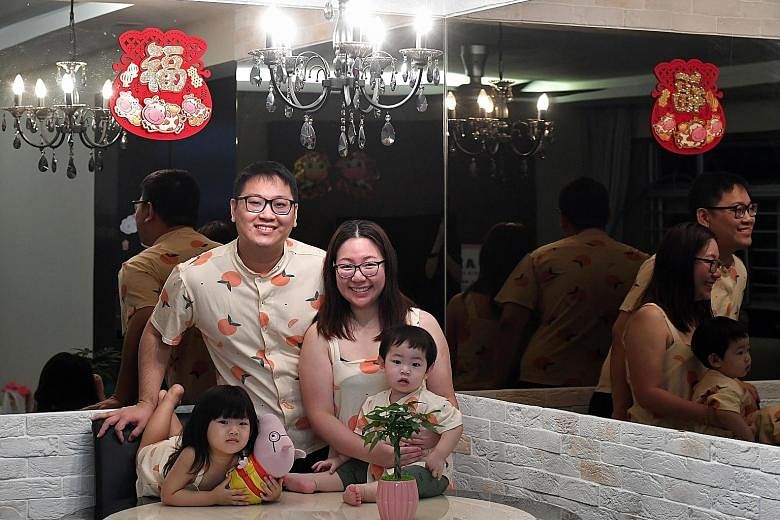 Ms Steffi Ng with her husband Lee Wen Jie and their children at their Yishun home. Although she bought fewer snacks this year, the family will still don matching outfits as part of celebrations.