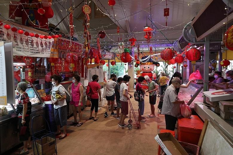 Customers at Teck Ghee Court Market and Food Centre in Ang Mo Kio Avenue 1 on Friday. Crowd controllers from Ang Mo Kio Town Council said that 180 people are allowed inside at any one time. Access controls are lifted at 11am, when the morning rush ea