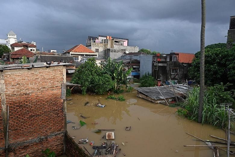 Flood waters submerging homes in south Jakarta after heavy rain yesterday. More than 1,000 people in the Indonesian capital have been evacuated. The wet conditions are expected to continue until next month or April. PHOTO: AGENCE FRANCE-PRESSE