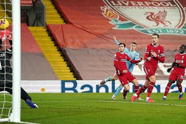 Manchester City's Phil Foden (in blue) scoring the fourth goal for his team against Liverpool on Sunday. The visitors' 4-1 victory ended their 18-year winless run at Anfield.