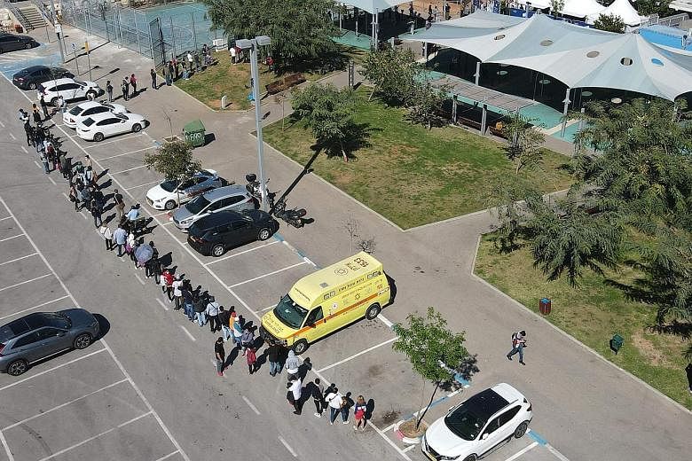 Foreign residents in Israel queueing at the Tel Aviv Sourasky Medical Centre yesterday to be vaccinated against Covid-19. World Economic Forum founder Klaus Schwab said that a goal of one of the forum's initiatives was to reduce the time taken to dev