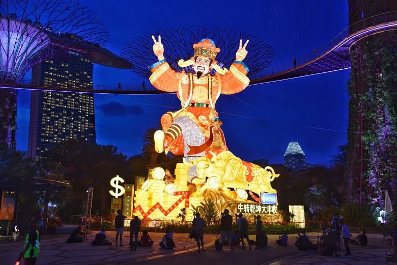 Above: The lanterns at Gardens by the Bay include an 18m-tall God of Fortune display. Left: Prime Minister Lee Hsien Loong, accompanied by Mrs Lee, on a tour of the exhibits on the opening day of the River Hongbao festivities at Gardens by the Bay la