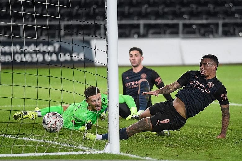 Swansea goalkeeper Freddie Woodman and Manchester City's Gabriel Jesus (right) watching the ball cross the goal line on Wednesday. The goal was scored by Kyle Walker, who is not in the frame.