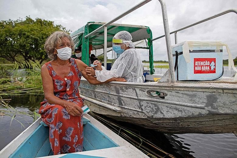 Ms Olga D'arc Pimentel, 72, getting a dose of the AstraZeneca vaccine on the banks of the Rio Negro in Amazonas state, Brazil, on Tuesday. World Health Organisation experts are awaiting more specific data on the vaccine's efficacy in people over 65, 