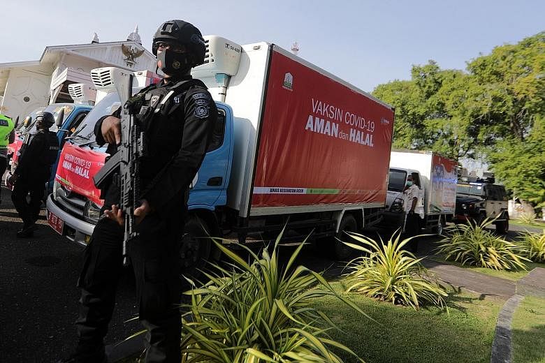 A security officer guarding containers carrying Covid-19 vaccines to be distributed to urban areas in Aceh, Indonesia, last week. Last month, state-owned pharmaceutical company Bio Farma began distributing three million doses of its Coronavac vaccine