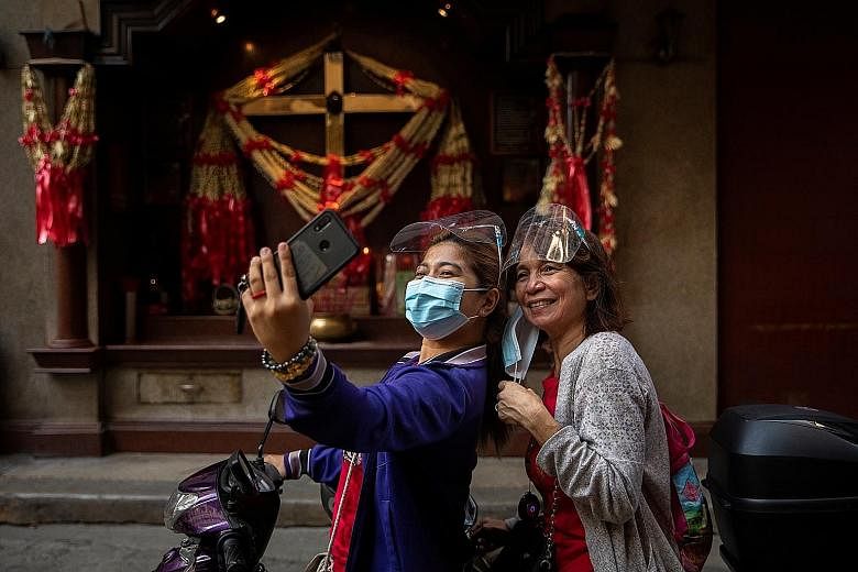 Two women taking a selfie in front of an altar in Manila's Chinatown on Friday, the first day of Chinese New Year. PHOTO: REUTERS