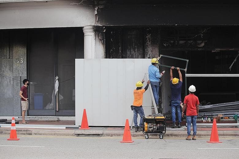 Workers cordoning off the accident site at 37 Tanjong Pagar Road yesterday. The Traffic Police told The Straits Times that they would explore further enforcement operations in the vicinity.