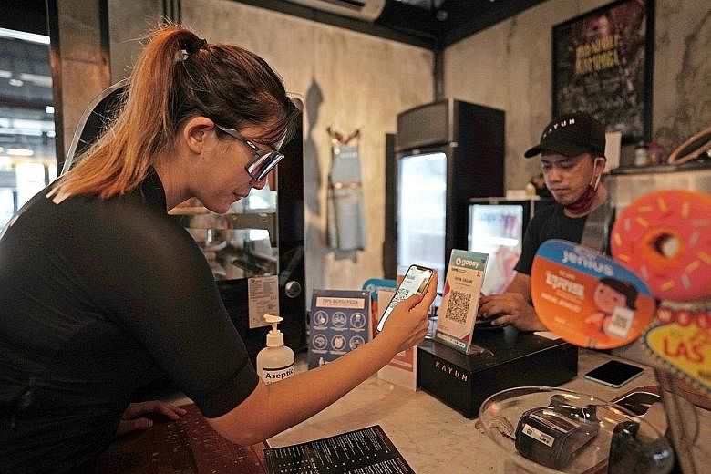 A customer making payment for her purchases using digital payment service GoPay in Jakarta. Indonesians have switched to digital payment methods to minimise face-to-face interactions and trips to physical banks.