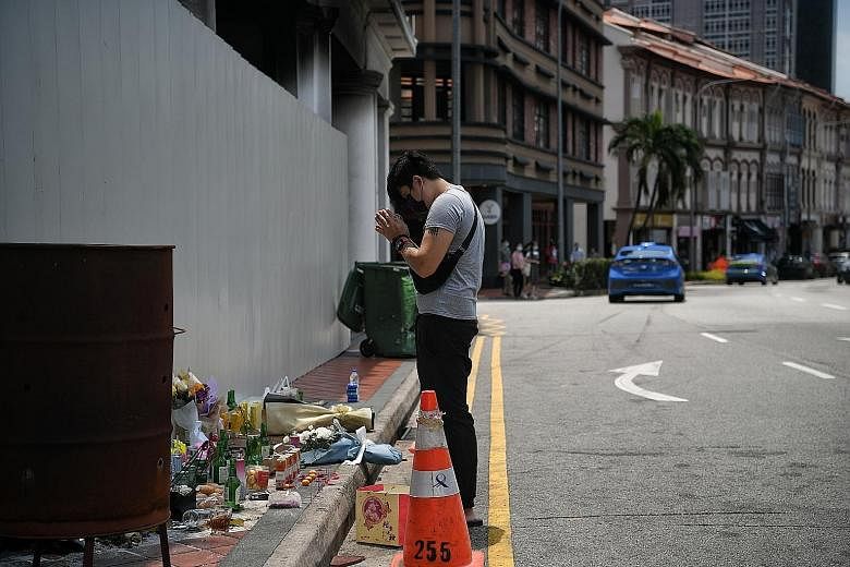 Mr Wisely Chung, 23, a friend of the late Mr Gary Wong and Mr Jonathan Long, paying his respects at the crash site in Tanjong Pagar yesterday. ST PHOTO: KUA CHEE SIONG Mr Jonathan Long, the driver of the car in the crash, with his girlfriend Raybe Oh