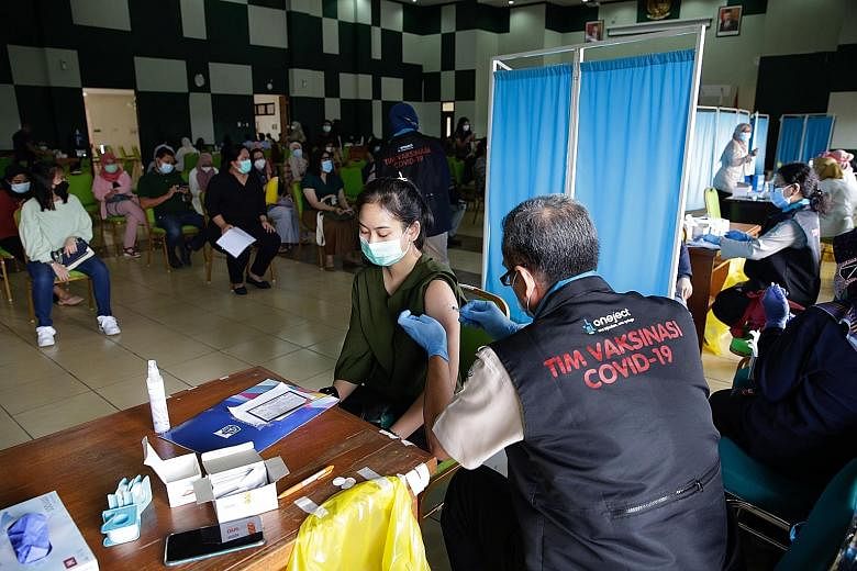 A healthcare worker receiving a dose of the Sinovac vaccine during a mass vaccination drive in Jakarta on Monday. Apart from making Covid-19 vaccination compulsory, the Indonesian government will also allow a private sector role in the programme. PHO