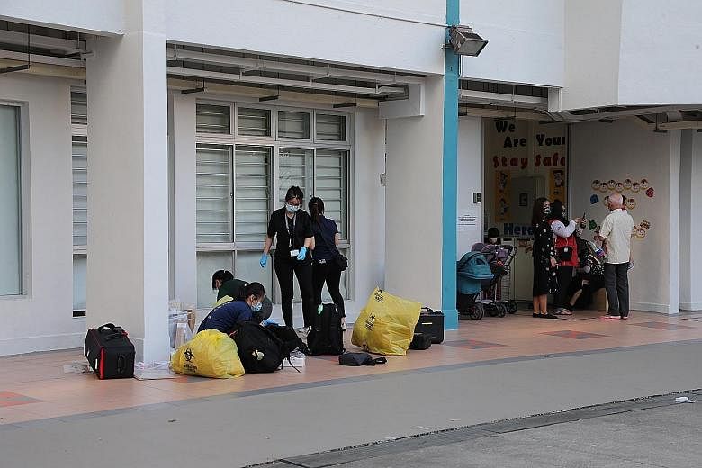 Police officers at Block 308 Jurong East Street 32 yesterday morning, near where a 34-year-old woman was found fatally stabbed on Tuesday night.