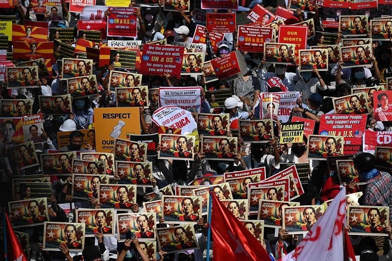 Protesters holding signs of deposed civilian leader Aung San Suu Kyi during a demonstration in Yangon yesterday. Social media has linked them to Hong Kong and Thai users who have swopped tips on staying safe during protests.