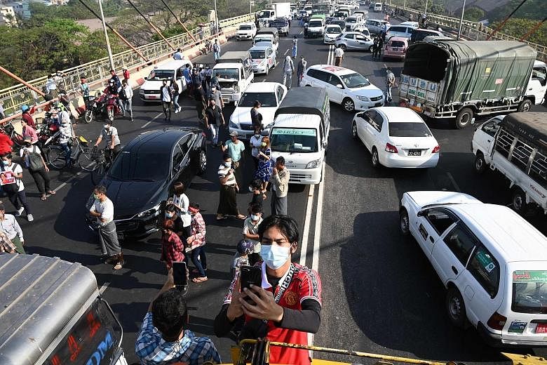 Protesters blocking a bridge with their cars during a demonstration in Yangon yesterday. The military has tried to put a chokehold on the country's Internet access, but users circumvented a nationwide blackout as well as social media restrictions wit