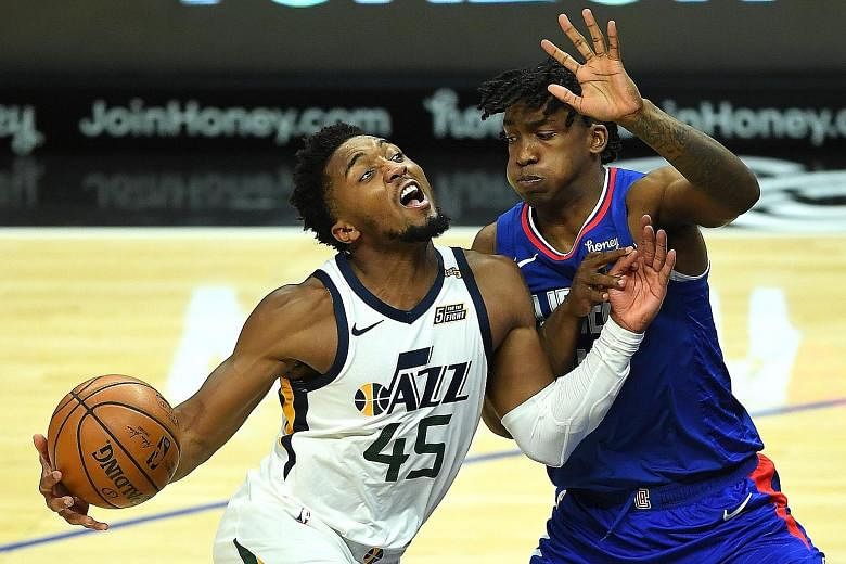 Jazz guard Donovan Mitchell is blocked by Clippers guard Terance Mann as he drives to the basket in their NBA game at Staples Centre on Wednesday. He led all scorers with 24 points as the Western Conference leaders beat their under-staffed opponents 