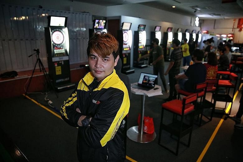 Above: Leslie Lee is a hawker who is also a Dartslive Official Player and a coach at Singapore Polytechnic. Below: The 33-year-old is hoping to one day win Dartslive's The World event as well as nurture the next generation of local players.
