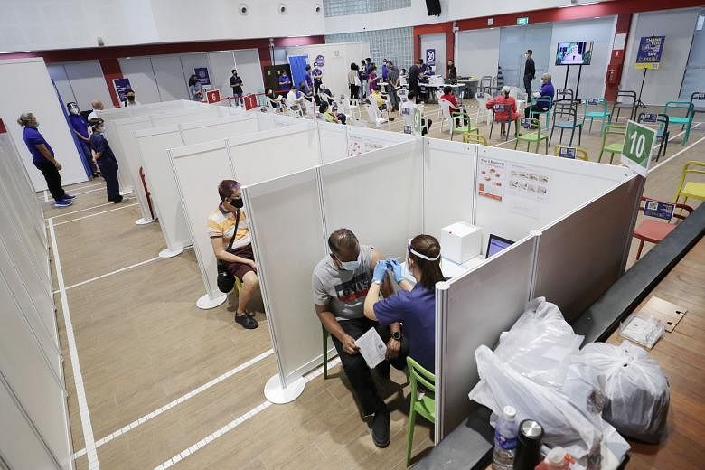 Above and left: People turning up to receive their Covid-19 vaccination jabs at the Jalan Besar Community Club yesterday. Having more than one approved vaccine provides the country some sort of insurance as Singapore will not need to rely on a single