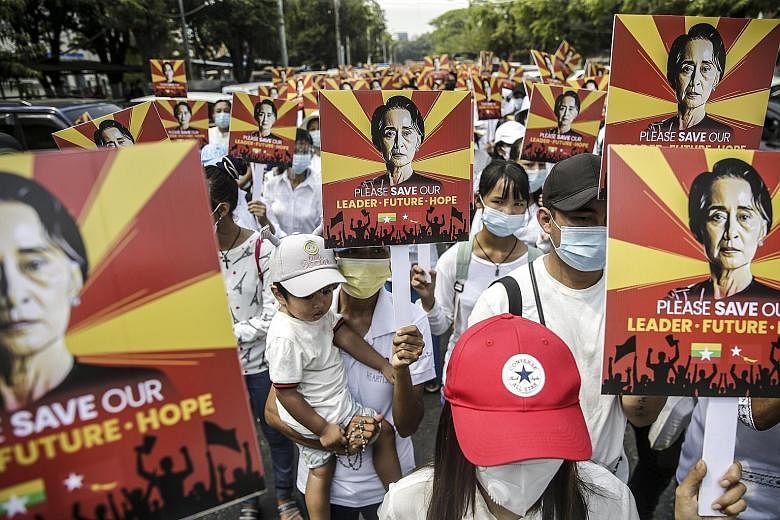 Supporters of elected leader Aung San Suu Kyi holding placards during a rally against the coup in Yangon yesterday. The army seized power after alleging fraud in the Nov 8 election, detaining Ms Suu Kyi and others. PHOTO: EPA-EFE