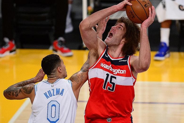 Wizards centre Robin Lopez goes for a basket but is blocked by Lakers forward Kyle Kuzma during their game, which the visitors won 127-124 after overtime.