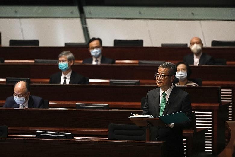Hong Kong finance chief Paul Chan delivering his budget speech at the Legislative Council in the city yesterday. He warned that progress in the city's economic recovery would depend on developments in the Covid-19 pandemic.