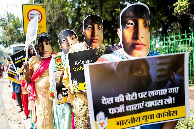 Demonstrators wearing masks with the image of climate activist Disha Ravi in New Delhi on Monday to protest against her arrest under India's sedition law earlier this month. She was released on bail on Tuesday.
