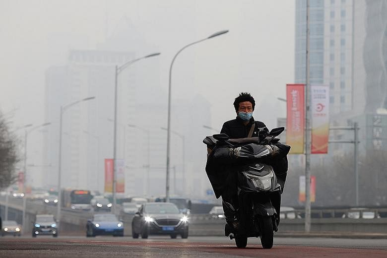 A motorcyclist wearing a face mask during a smoggy day in Beijing on Feb 13. Pollution across China fell significantly in the early part of last year due to coronavirus-related lockdowns. PHOTO: REUTERS