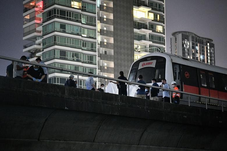 Singapore Police Force and Singapore Civil Defence Force personnel with the stationary MRT train on the east-bound track near Kallang station yesterday. SMRT said the incident took place at about 9.30pm.