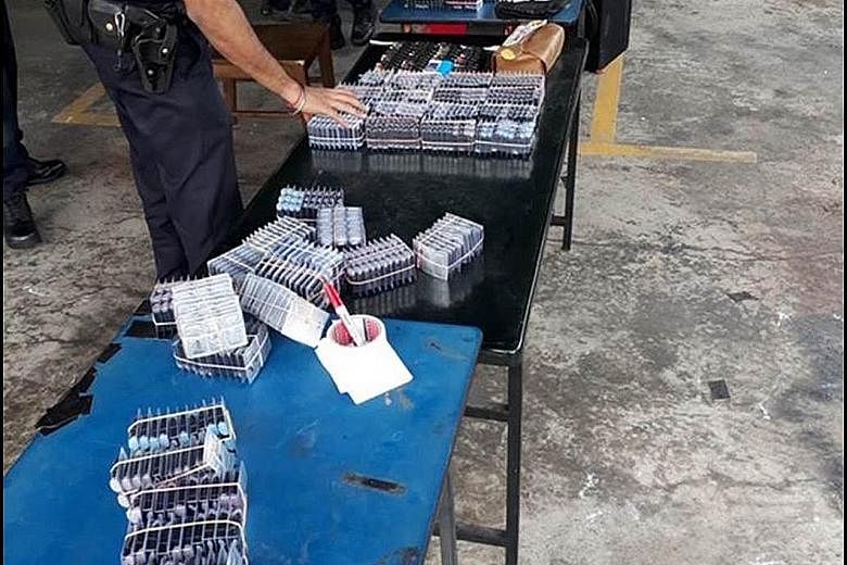 (Left): HSA's operation last July seized 5,368 vaping products with a street value of about $53,680. (Above): ICA officers at Woodlands Checkpoint detected over 2,000 e-vaporiser products hidden in a car on Jan 23 last year. HSA was alerted and this 
