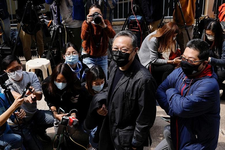 Activist Sam Cheung hugging his wife before he was charged yesterday with conspiracy to commit subversion. He was arrested in a raid on Jan 6. Pro-democracy activist Benny Tai (left) walking past journalists yesterday as he arrived to report at a Hon