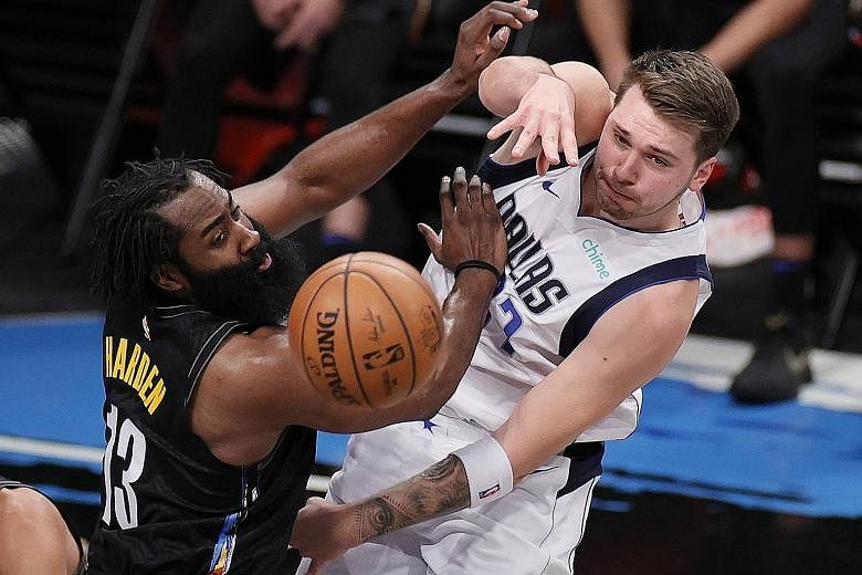 Dallas' Luka Doncic passing despite the attentions of Brooklyn's James Harden in their NBA game on Saturday. The Slovenian scored 27 points in his team's 115-98 road win.