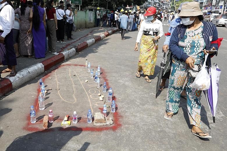 Food and water laid out by people as a tribute to a young man who died during a protest against the military coup in Yangon. Police fired on protesters yesterday in the bloodiest day in weeks of demonstrations against the Feb 1 military coup. PHOTO: 