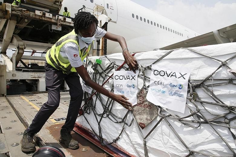 Workers in the city of Abidjan last Friday, unloading boxes of the AstraZeneca-Oxford vaccine - the Ivory Coast's first batch of Covid-19 shots received under the Covid-19 Vaccine Global Access (Covax) scheme. Singapore helped to establish the Covax 