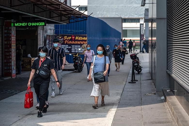 Pedestrians in Kuala Lumpur yesterday. Under the second-tier conditional movement control order, more business activities are expected to be allowed, although all shops and malls will continue to adhere to health protocols such as checking customers'