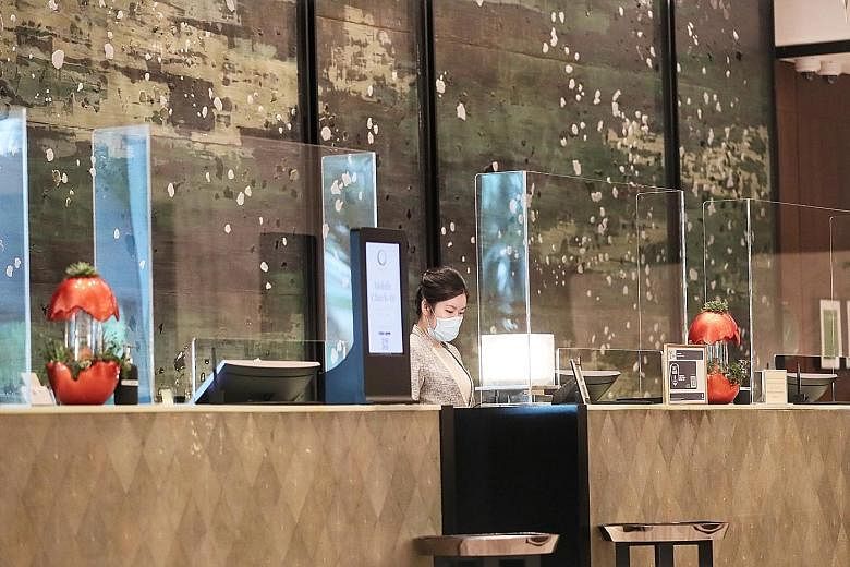 The Shangri-La Hotel Singapore's reception counters, fitted with plastic shields to minimise contact between people, in June last year. Hotel operators typically pay between $300 and $500 to renew their licences yearly, depending on the number of roo