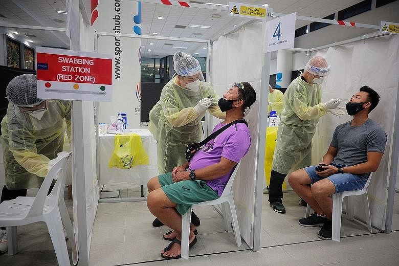 Above: Fans for the last two rounds of the Singapore Tennis Open taking antigen rapid tests before entering the OCBC Arena. Far left and left: Staff in full personal protective equipment sanitising the arena while ball kids donned gloves, masks and f