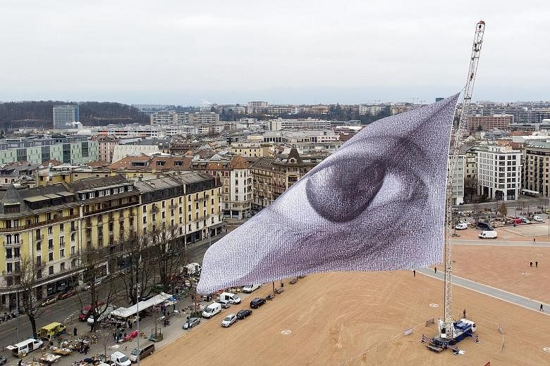 A photograph taken with a drone showing a giant flag, named "We are Watching: The Eyes of the World", being hoisted yesterday in Geneva, Switzerland. The flag was designed by artist Dan Acher and presented for the first time during the United Nations