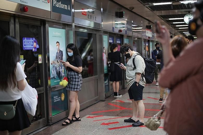 Commuters at City Hall MRT station yesterday. The number of unlinked cases in the community has increased to three cases in the past week, from two cases the week before.